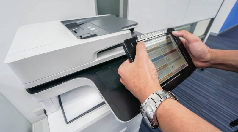 Businessman hold touch screen for printing document from office printer machine